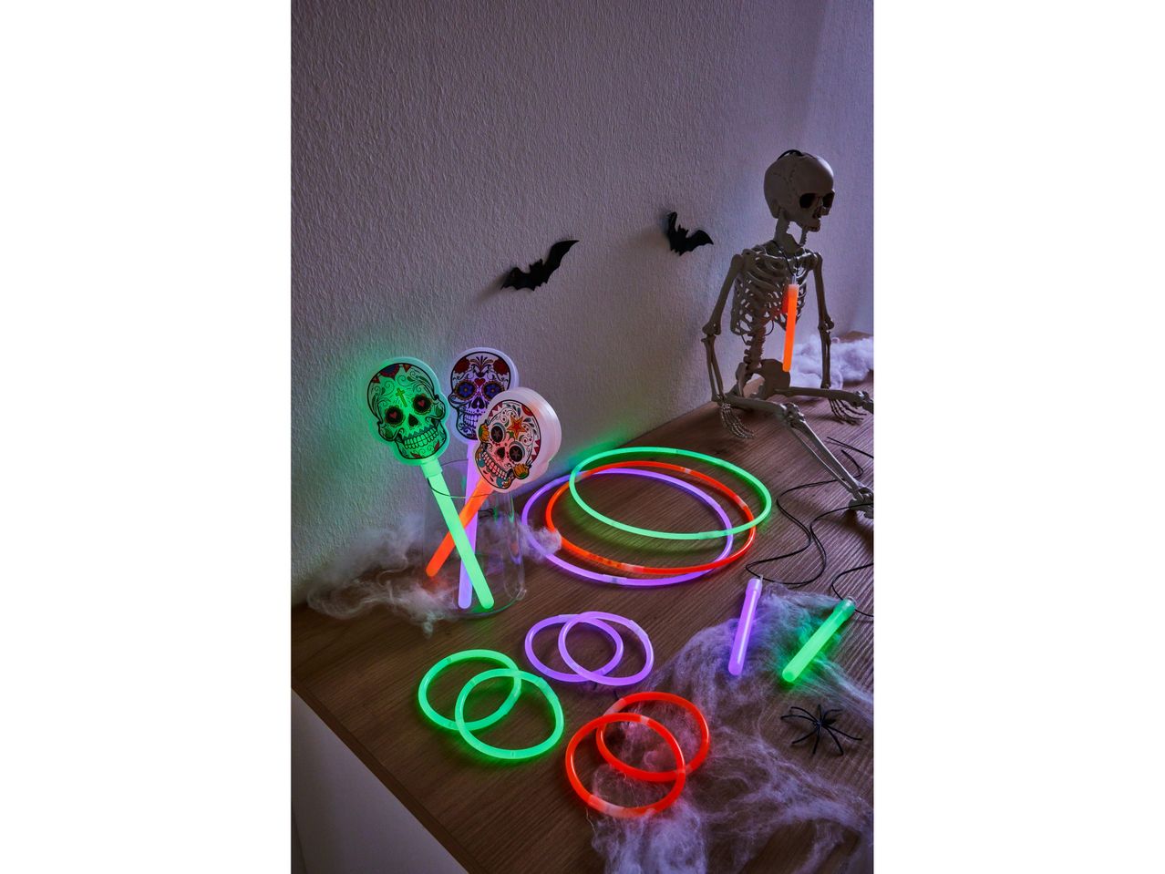 Halloween decorations with glow sticks, sugar skull wands, and a skeleton.