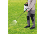Person spraying grass with a Parkside cordless sprayer.