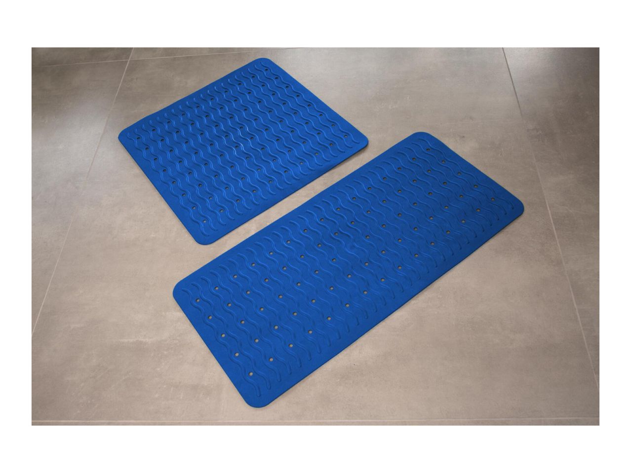 Two blue anti-slip bath mats with a wavy pattern on a tiled floor.