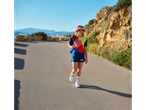 Mulher caminhando em uma estrada com roupas e boné da Trek e Lidl.