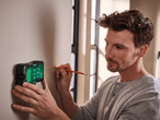 Mann markiert mit Parkside Laser-Wasserwaage und Bleistift eine Wand.