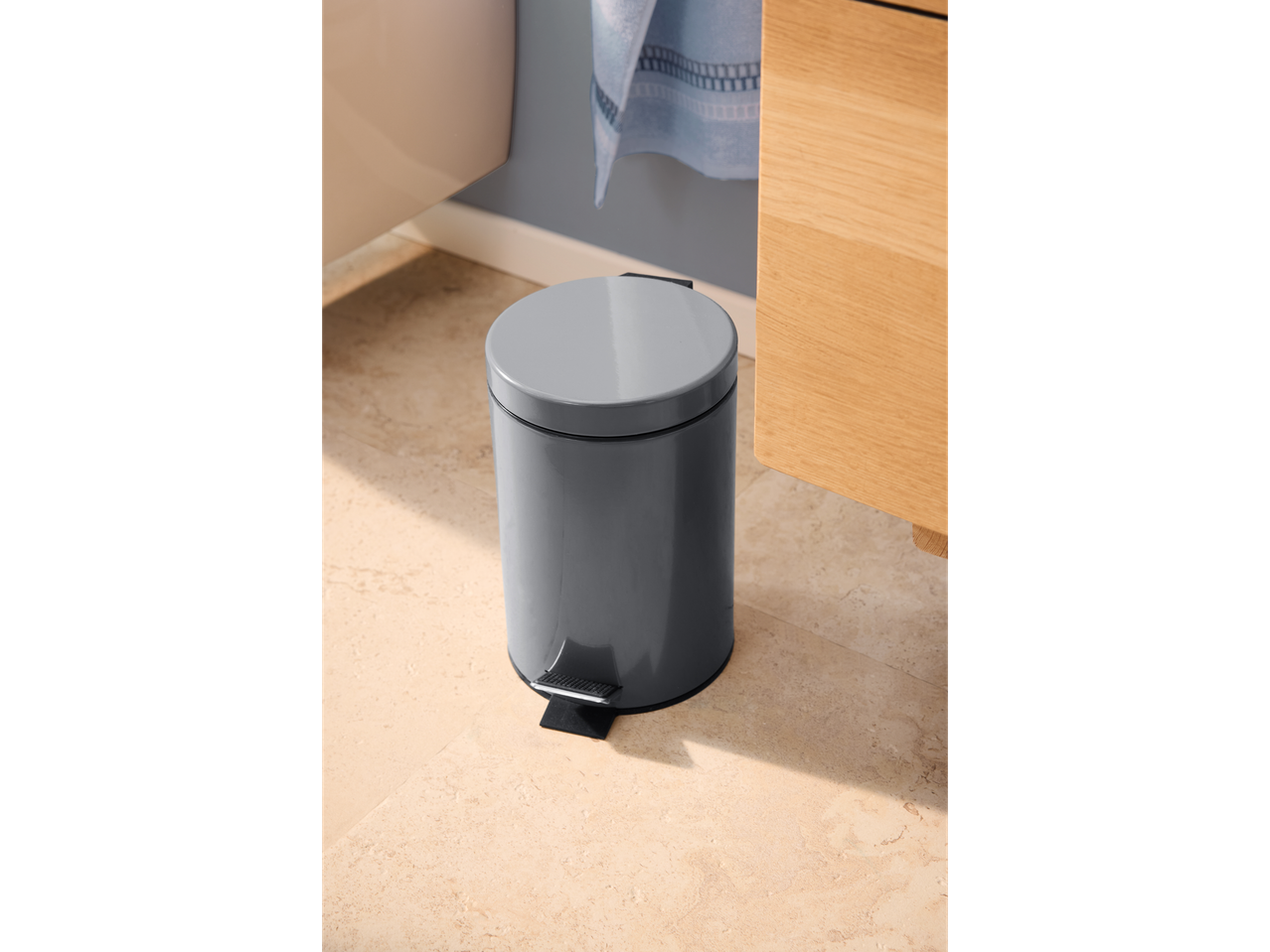 Caixote do lixo com pedal Livarno cinzento num chão de azulejos claros na casa de banho.