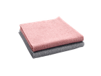 Deux chiffons en microfibre, un rose et un gris, pliés et empilés.
