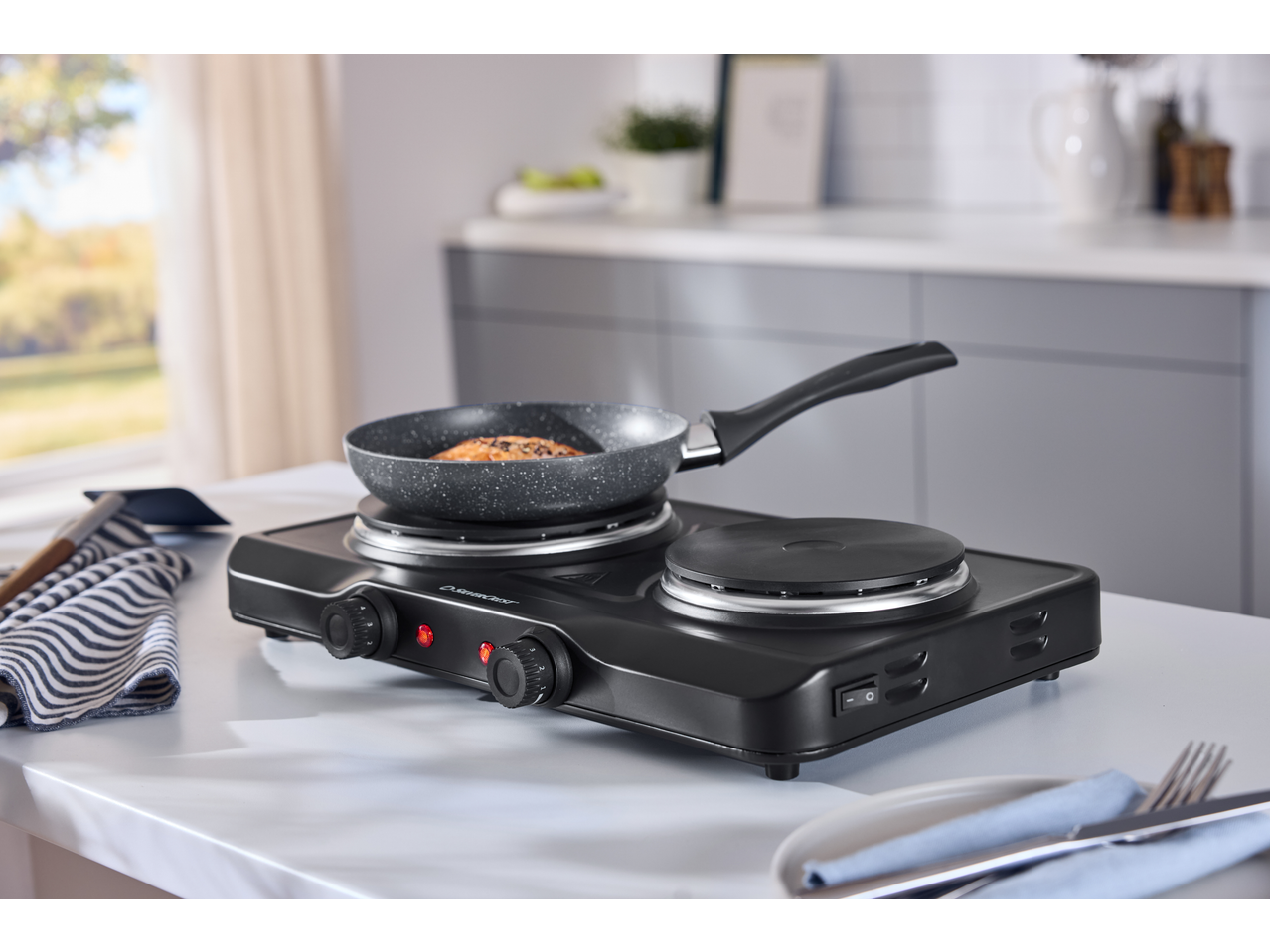 Placa dupla SILVERCREST com frigideira e comida na cozinha.