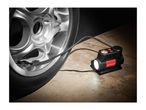 A portable air compressor inflating a car tire on a concrete floor.