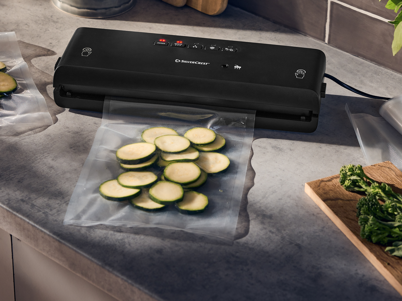 Συσκευή κενού με φέτες κολοκυθιού σε σακούλα κενού σε πάγκο κουζίνας.