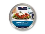 Rund beholder med makrelsalat, pyntet med dild og en skive rugbrød.