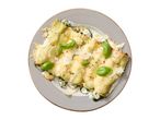 Overhead shot of cannelloni with spinach and ricotta, topped with cheese, basil, and pepper.
