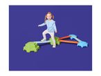 A young girl balancing on a colorful indoor obstacle course with stepping stones and beams.