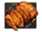 Sült csirkemell szeletek fekete kőtálcán, chili paprikával és fűszerekkel.