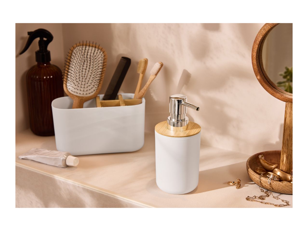 Bathroom accessories: white soap dispenser, organizer with brushes, comb, and mirror.