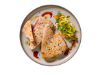 Bifes de atum selados com salada de vegetais e molho num prato.
