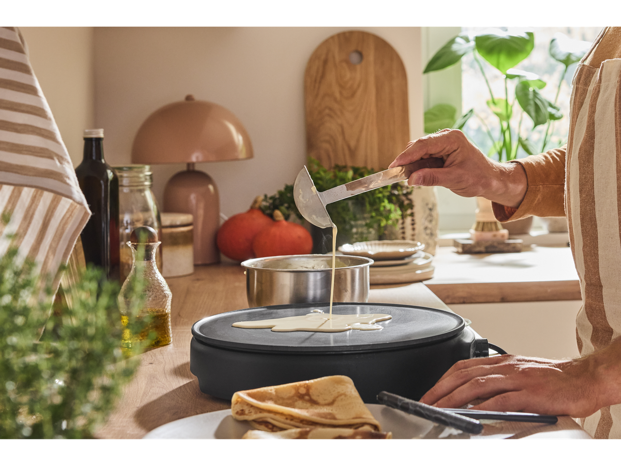 A person making crepes on a SILVERCREST® Crêpe Maker.