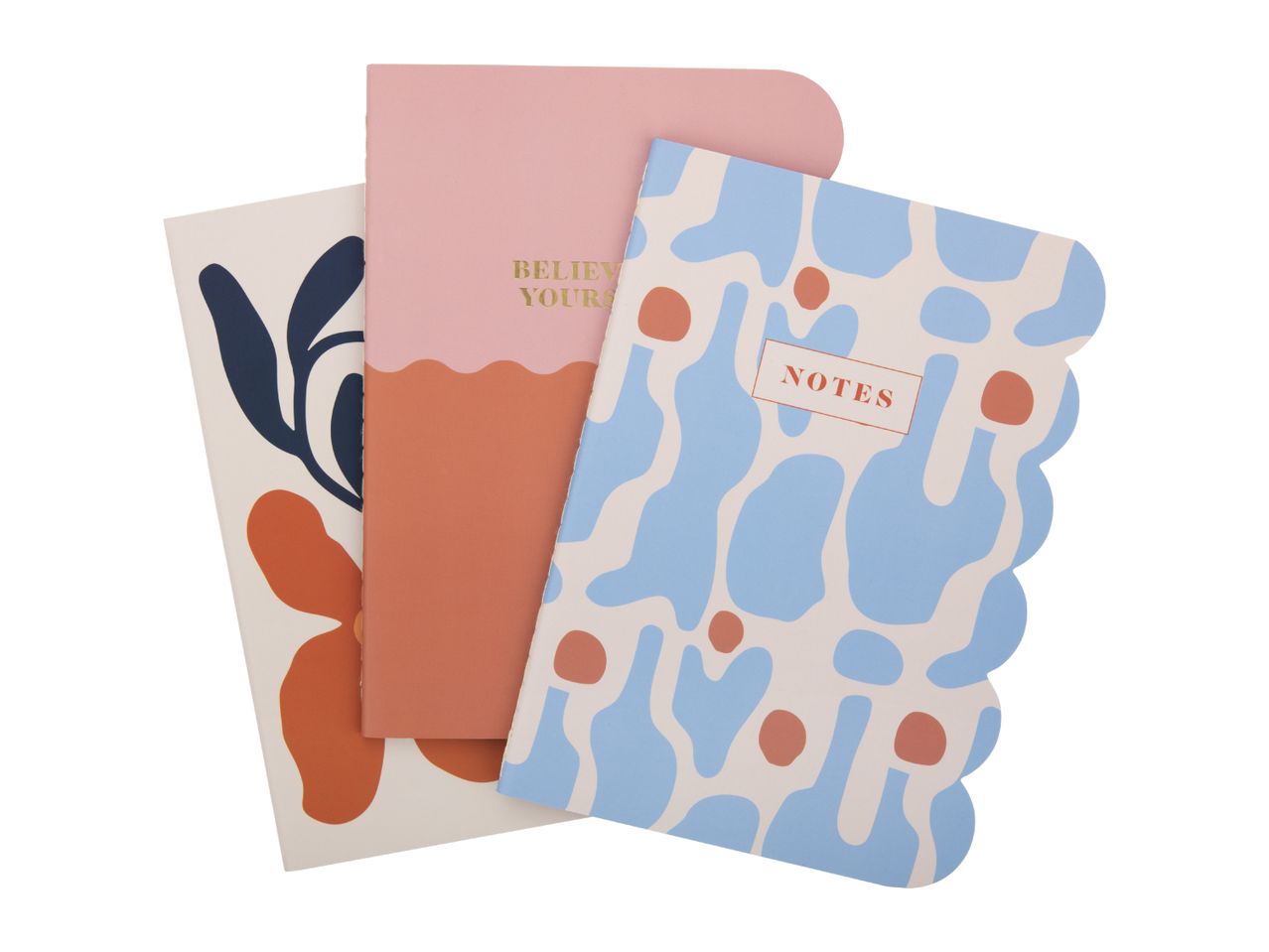 Three notebooks with abstract designs: one with blue and orange shapes, one with 'BELIEVE YOURS' text, and one with 'NOTES' text.