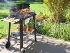 Kerti grill húsokkal és zöldségekkel, oldalsó asztalokkal és tárolópolccal.