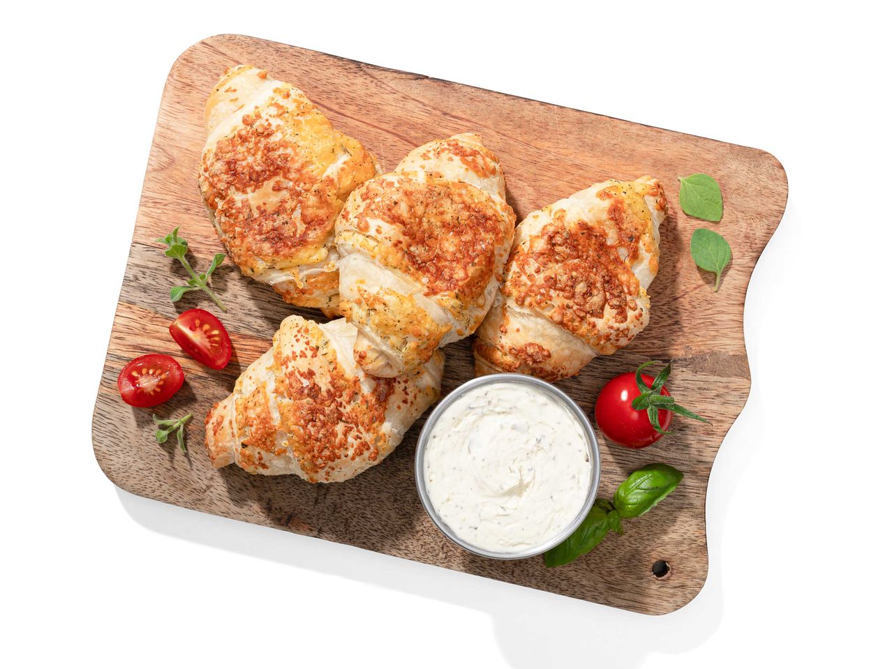 Sajtos croissant, mártás és cseresznye paradicsom fa táblán.