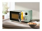 A mint green SilverCrest microwave oven with its door open, next to a bowl of pasta.