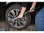 A person uses a Parkside torque wrench to tighten a wheel nut on a car.