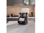 Robot de cuisine multifonction noir avec écran tactile affichant des recettes, sur un comptoir de cuisine.