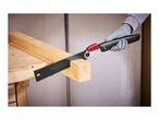 A person wearing gloves uses a folding saw to cut a wooden beam on a workbench.