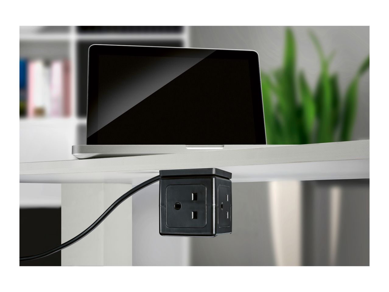 Laptop on a desk with a black power strip attached underneath.