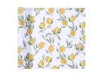 A white tablecloth with a pattern of yellow lemons and green leaves.