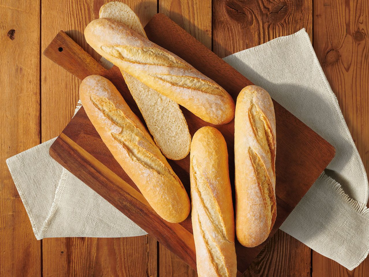Багети и хляб на дървена дъска.