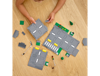 Copil construind o intersecție LEGO.