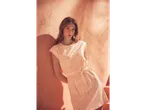 Model purtând o rochie scurtă de vară, piersică, cu imprimeu.