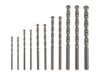 A set of various sizes of masonry drill bits arranged in increasing order of length and diameter.