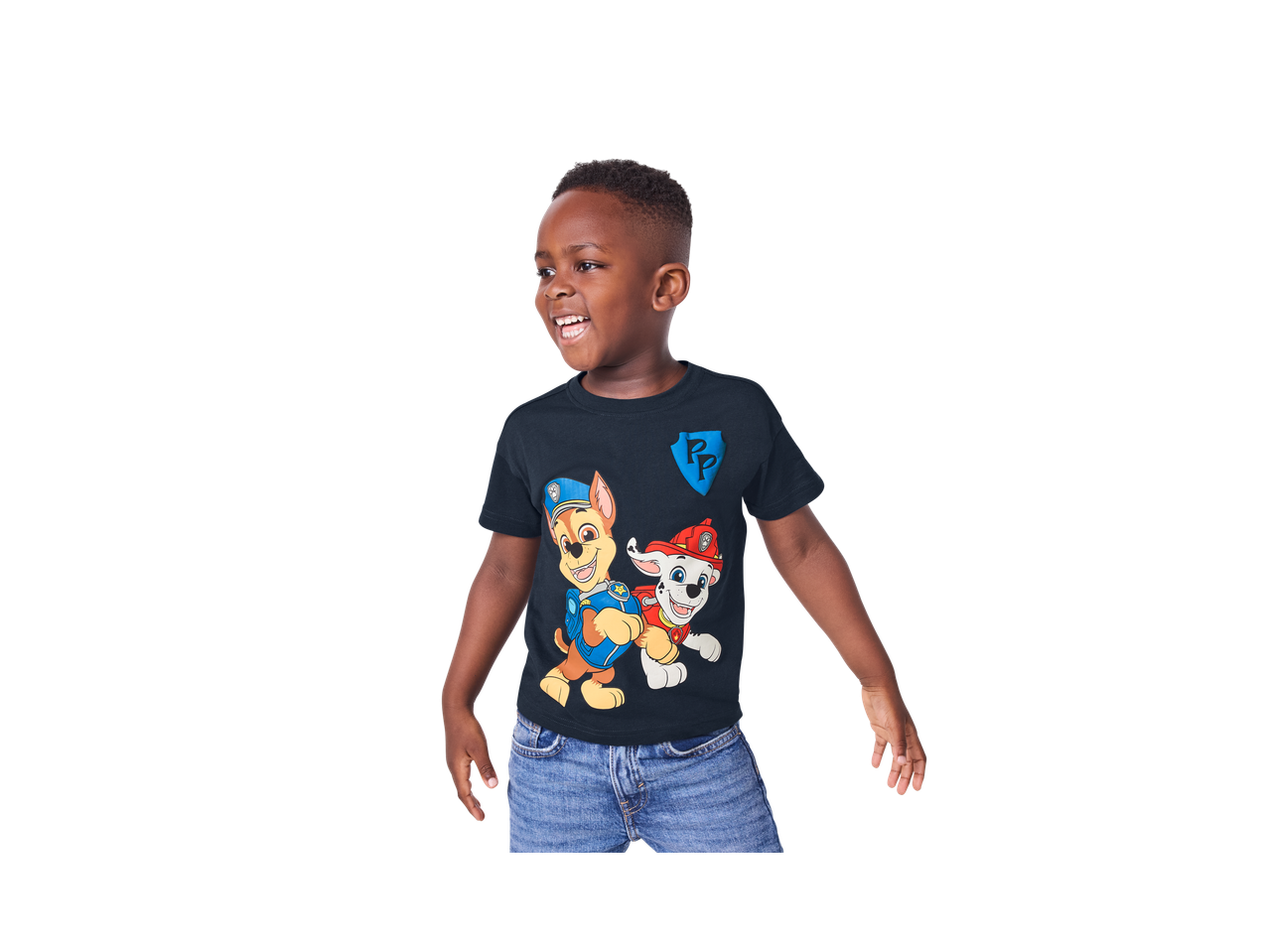 Dečak u tamnoplavoj majici sa likovima iz „Paw Patrol“ i plavim farmerkama.