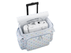 Sewing machine in a polka dot rolling bag.
