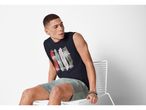 Man wearing a navy blue sleeveless graphic Tank Top and gray shorts.