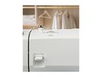 Close-up of a white sewing machine with a thread tension dial set to AUTO.