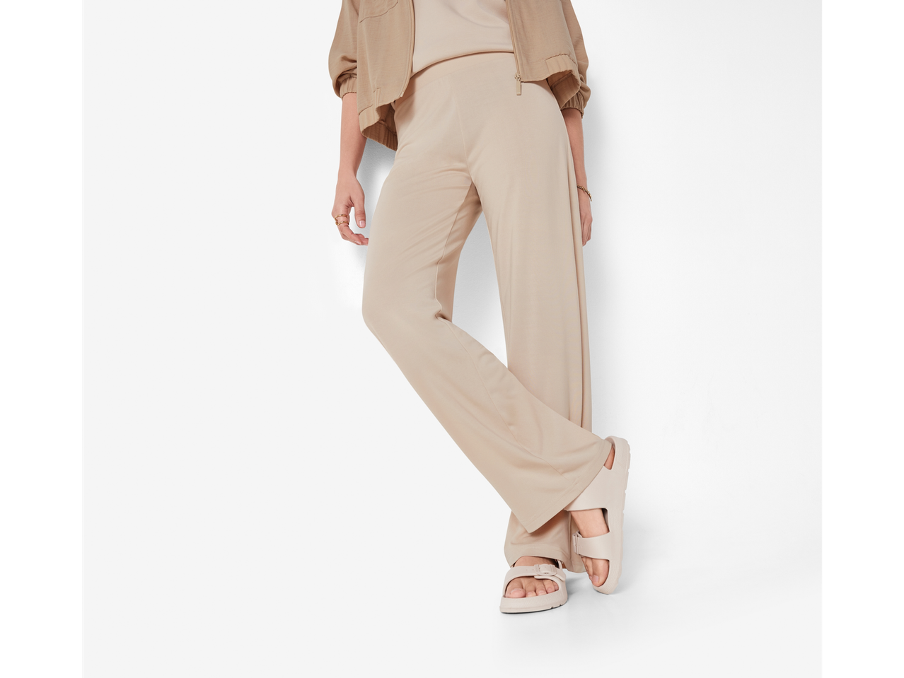 Žena u širokim hlačama i bež Birkenstock sandalama.