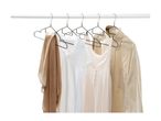 A collection of neutral-colored clothing items hanging on a white clothing rack.