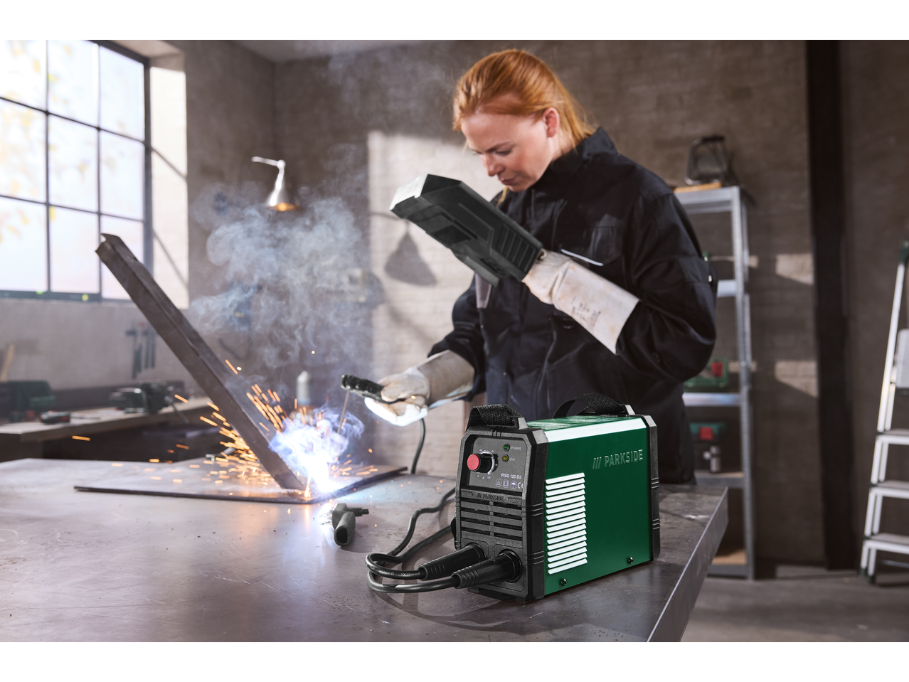 Frau schweißt Metall mit einem PARKSIDE Inverter-Schweißgerät.