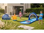 Children playing in a garden with a starfish sprinkler, a shark water slide, and a paddling pool.
