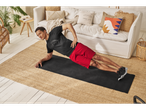 Man in black t-shirt and red shorts doing a side plank on a yoga mat.