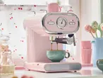Pink SilverCrest espresso machine brewing coffee into a green mug.