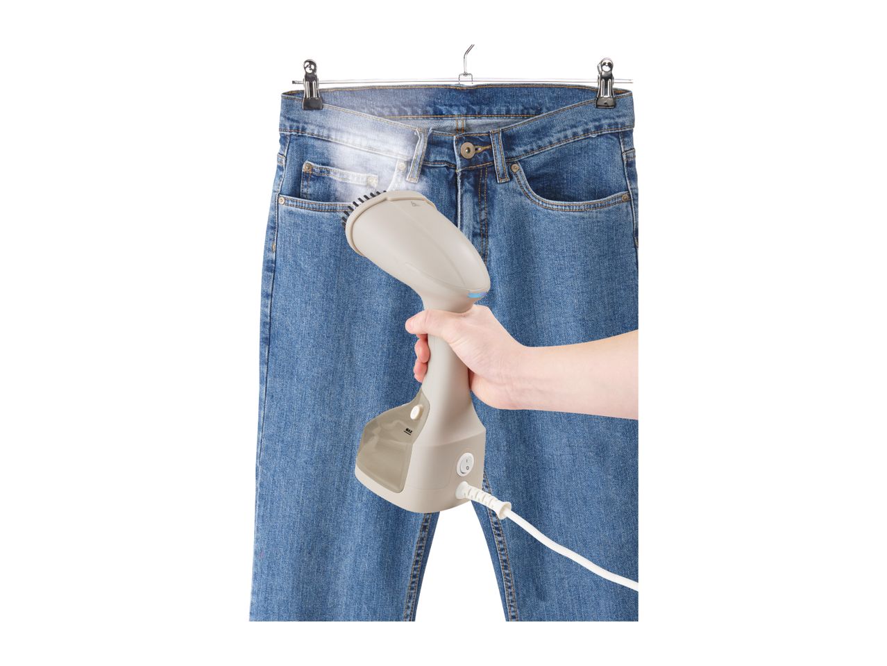 Handheld garment steamer being used on blue jeans hanging on a hanger