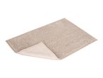 Beige rectangular bath mat with a textured, bobble surface, partially folded to show the underside.