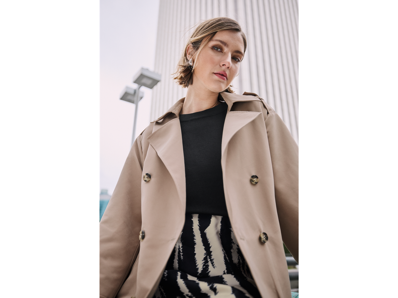 Elegante vrouw in beige jas en zebraprint rok.