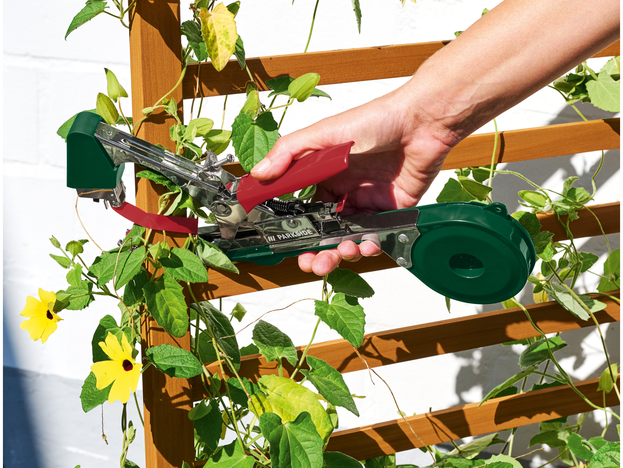 Roka uporablja klešče za vezanje PARKSIDE za pritrditev plezalke na oporo.
