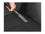 Hand holding a vacuum cleaner crevice tool on dark carpet