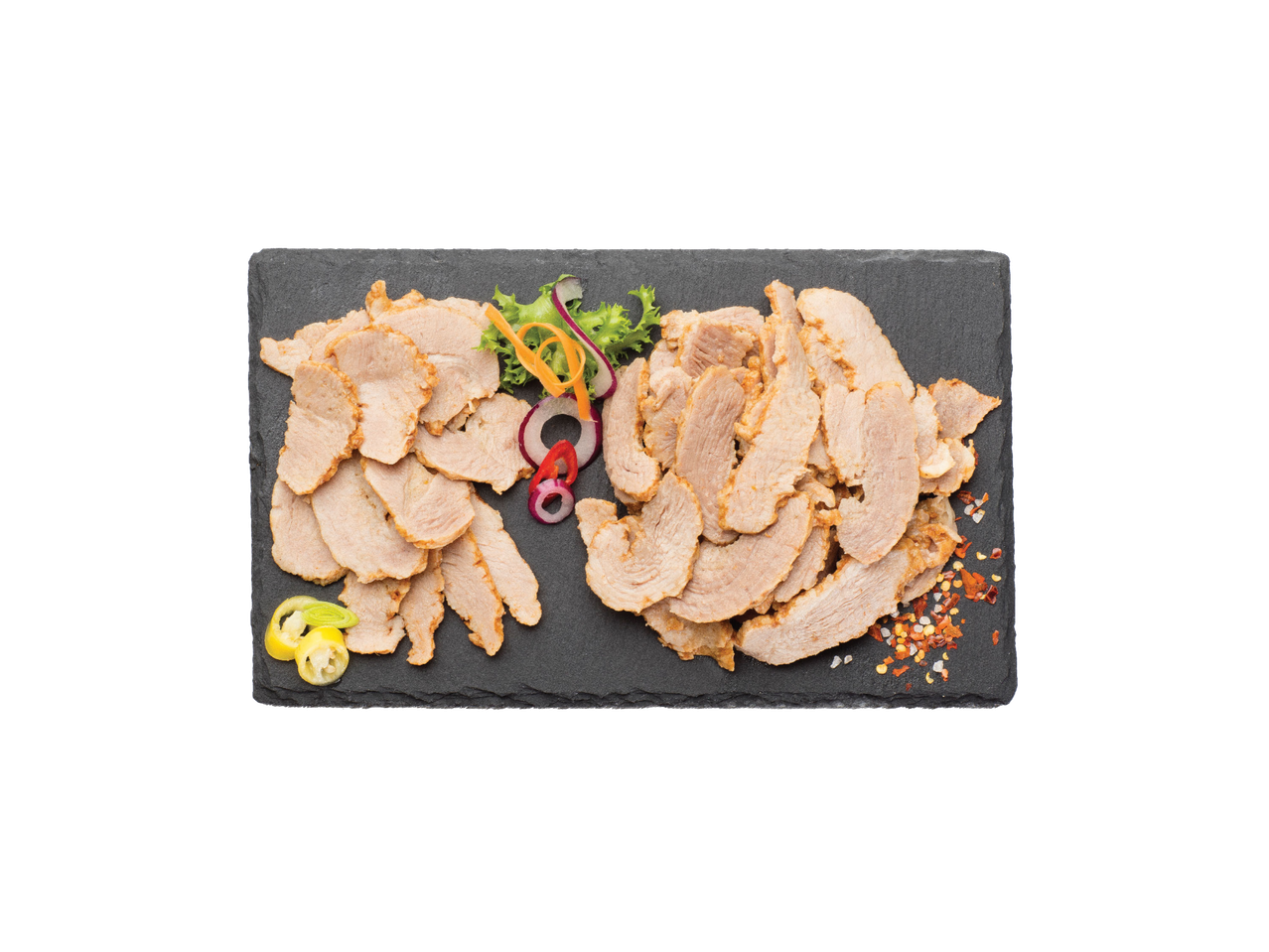 Tanko sečeno pečeno meso sa začinima i povrćem na crnoj ploči.