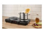 Portable electric hob with a pot of boiling spaghetti, oil, and chopped vegetables.