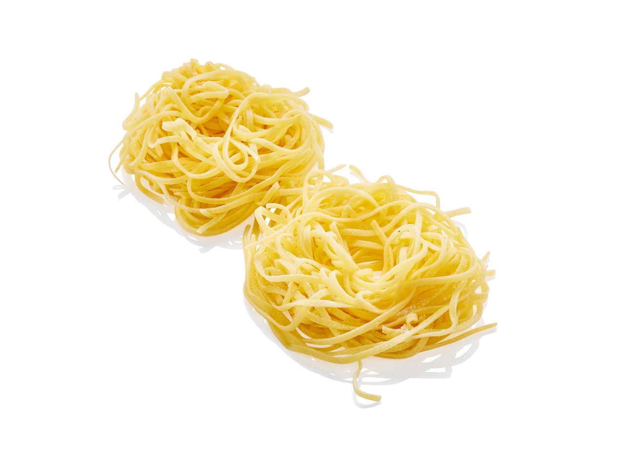 Két adag száraz tagliatelle tészta fehér háttér előtt.