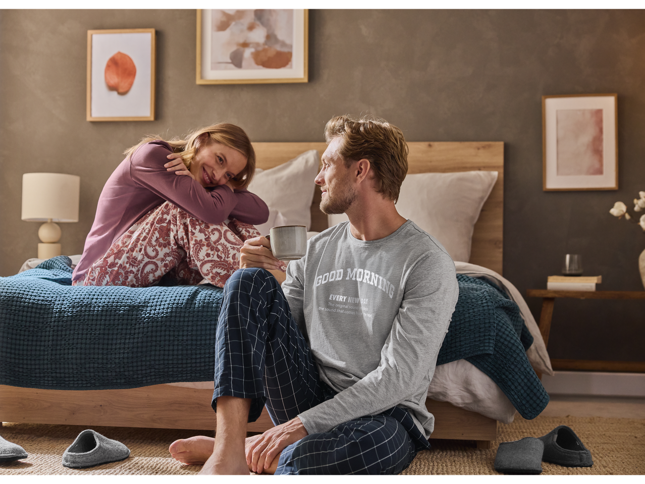 A couple in Esmara pyjamas, a woman in patterned pants and a man in a 'Good Morning' shirt.