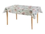 Rectangular tablecloth with a floral pattern in shades of pink, cream, and green, on a light green background, draped over a wooden table.